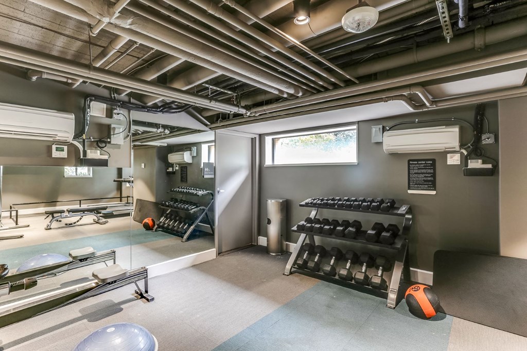 a workout room with weights and a window