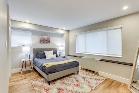a bedroom with a bed and a large window