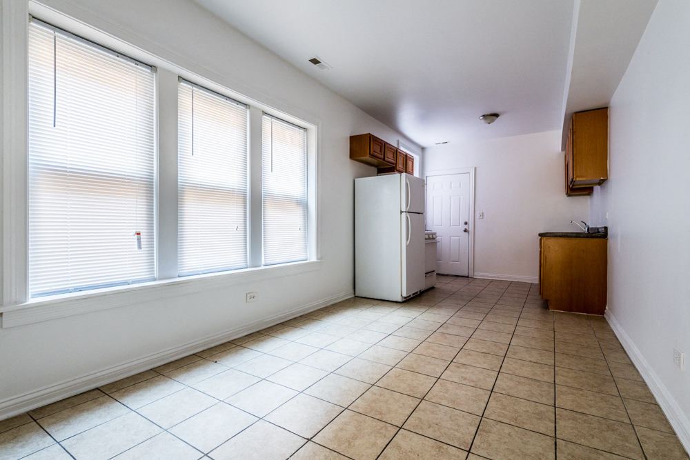 a kitchen with a large window and a white refrigerator