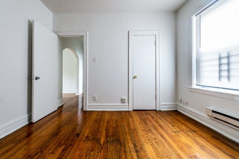 a living room with wood floors and a white door
