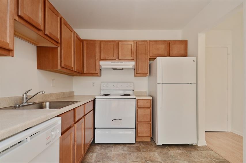 a kitchen with white appliances and wooden cabinets