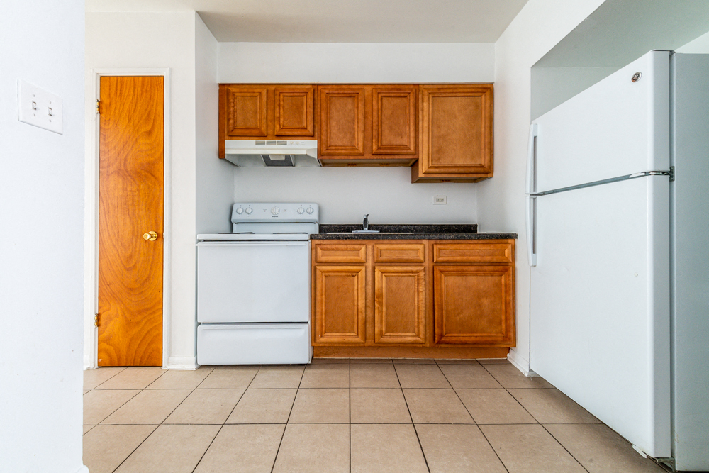 a kitchen with white appliances and wooden cabinets