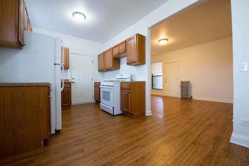 an empty kitchen with a stove and a refrigerator
