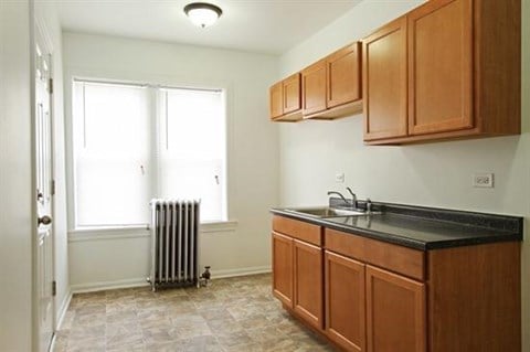 a kitchen with wooden cabinets and a sink and a radiator