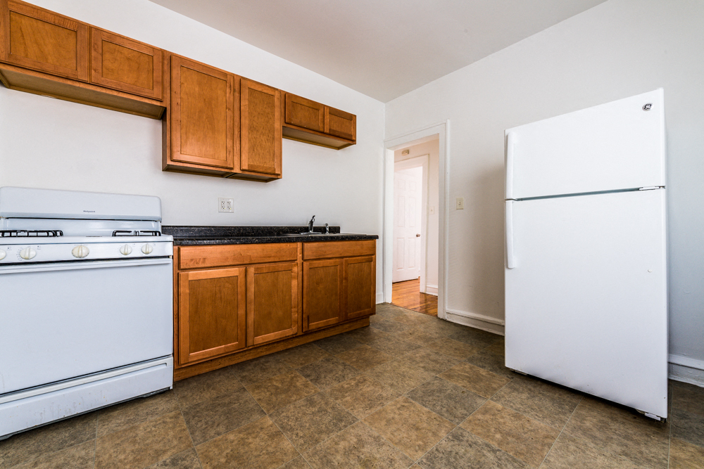 a kitchen with white appliances and wooden cabinets