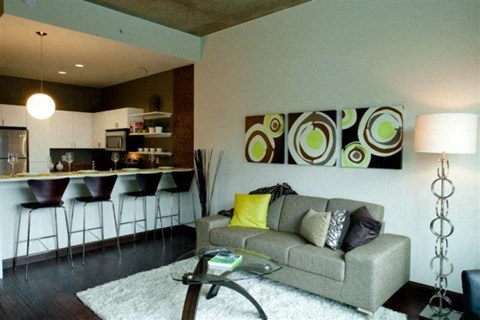 a living room with a couch and a kitchen with a bar