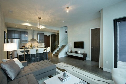 a living room with a couch a table and a kitchen