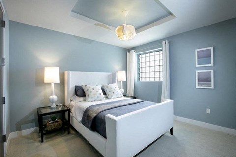 a bedroom with a white bed and blue walls