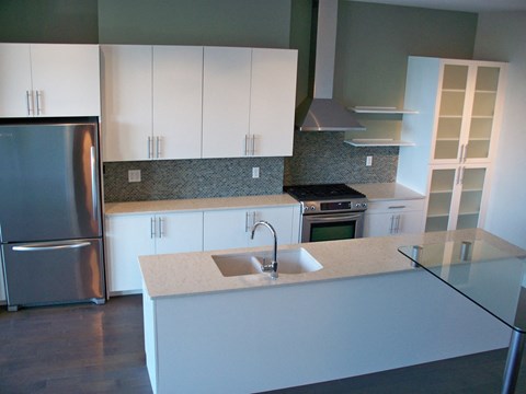 a kitchen with white cabinets and stainless steel appliances