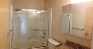 a bathroom with a shower and a toilet and a mirror