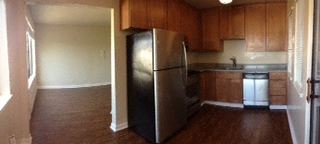 an empty kitchen with a stainless steel refrigerator