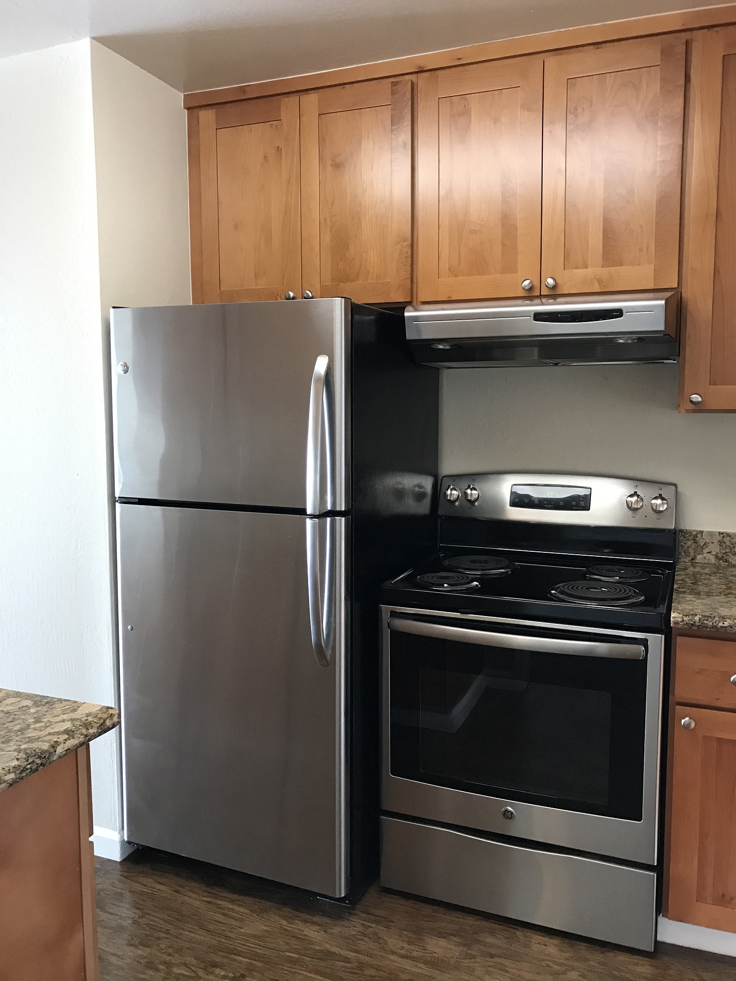 a kitchen with stainless steel appliances and wooden cabinets