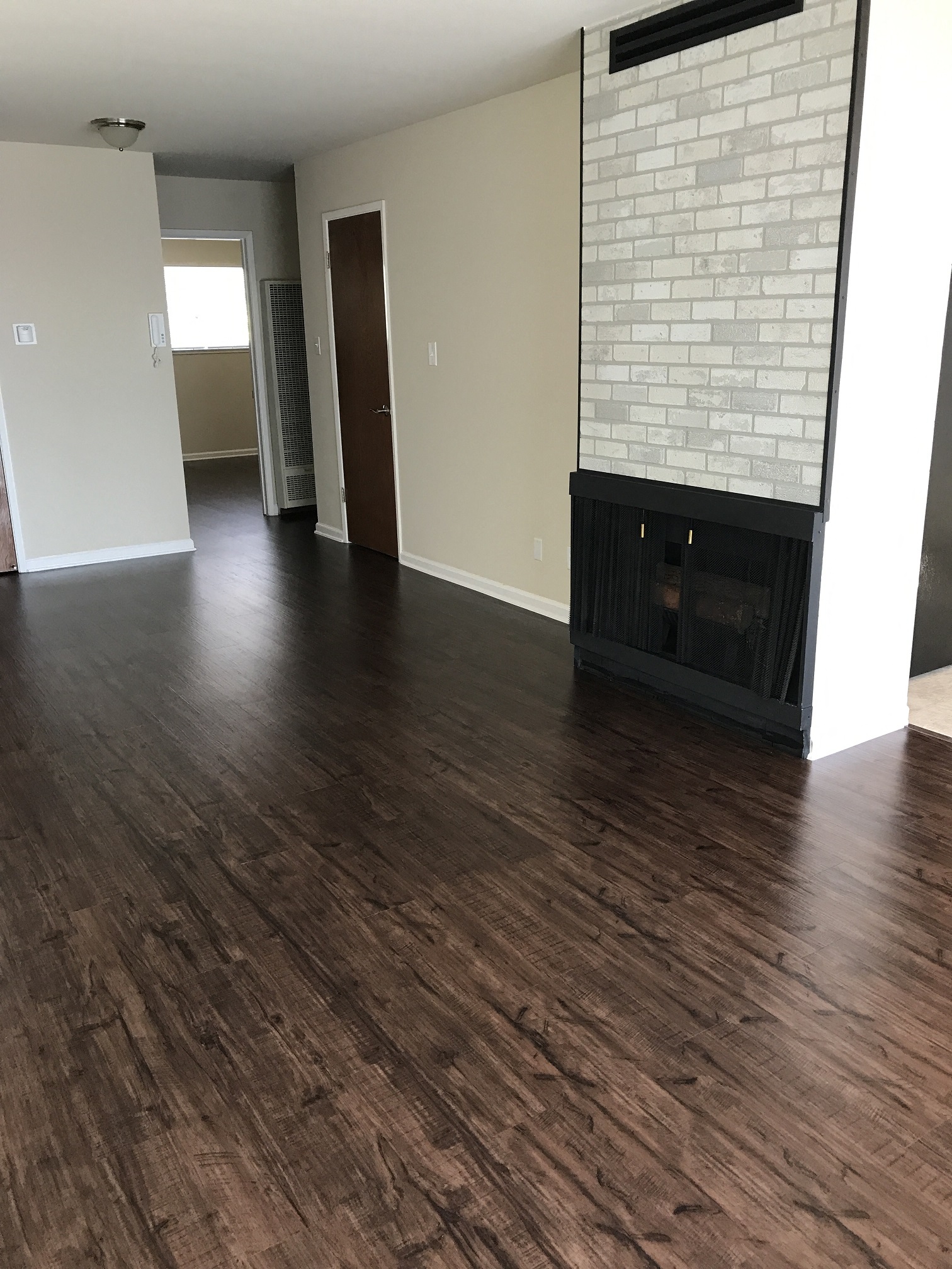 an empty living room with wood floors and a fireplace