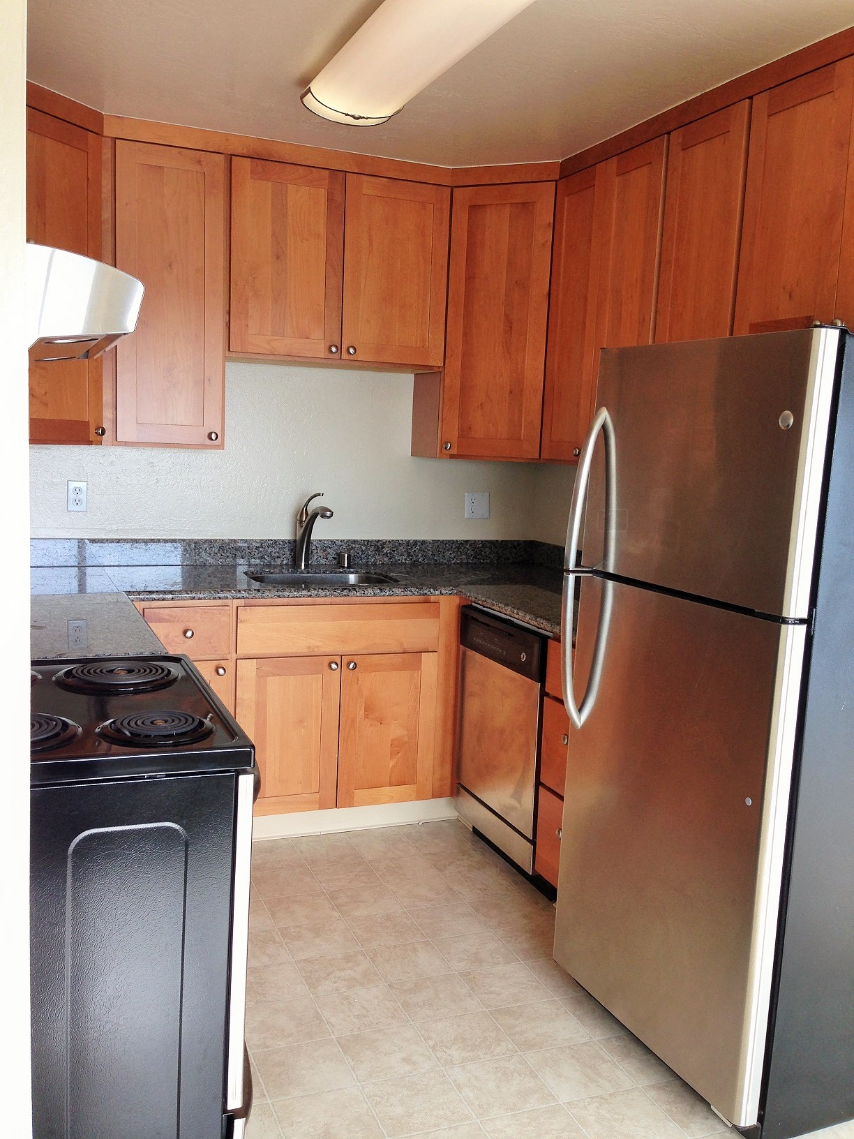 a kitchen with wooden cabinets and stainless steel appliances