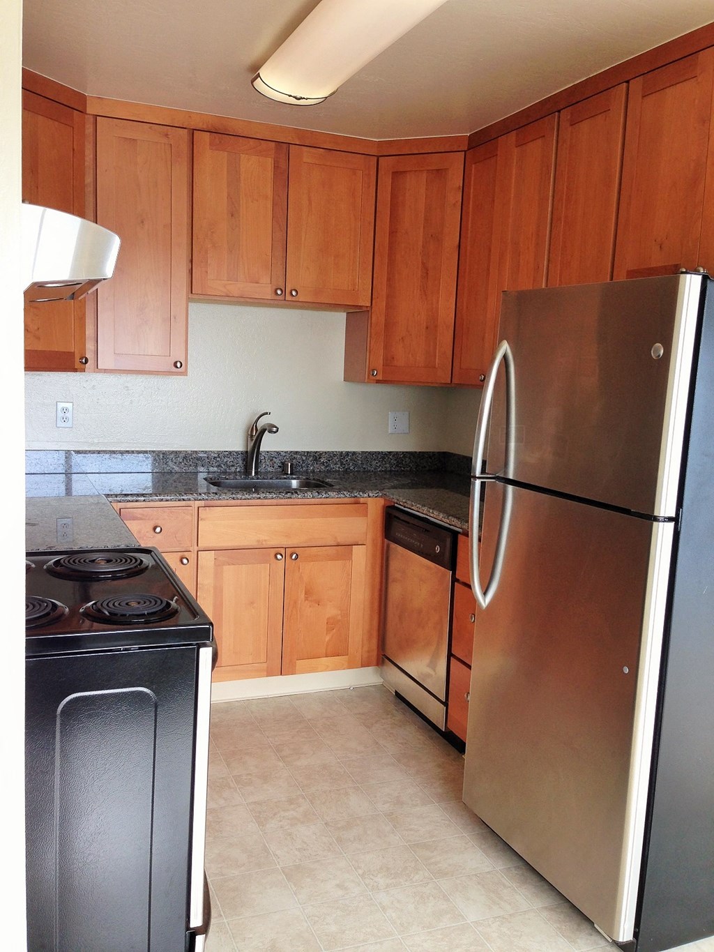 a kitchen with wooden cabinets and stainless steel appliances