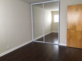 an empty room with a wooden floor and a sliding glass door