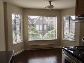 an empty kitchen with a stove and a large window