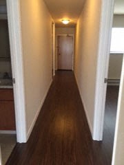 a hallway with a wood floor and white walls