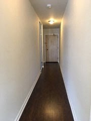 a long hallway with a wooden floor and a door