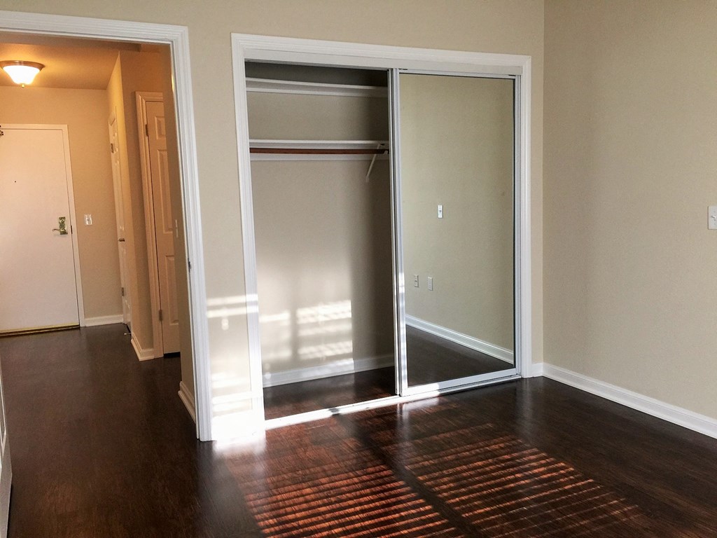 an empty living room with a hard wood floor and sliding glass doors