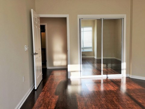 an empty living room with wood floors and sliding glass doors