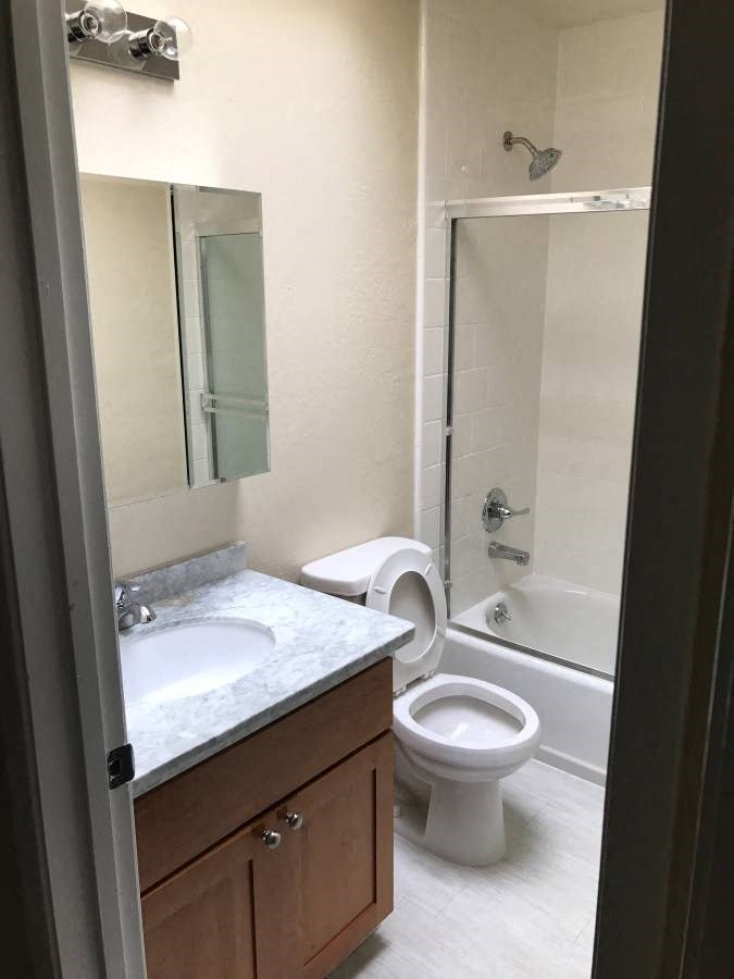 a bathroom with a toilet and a sink and a shower