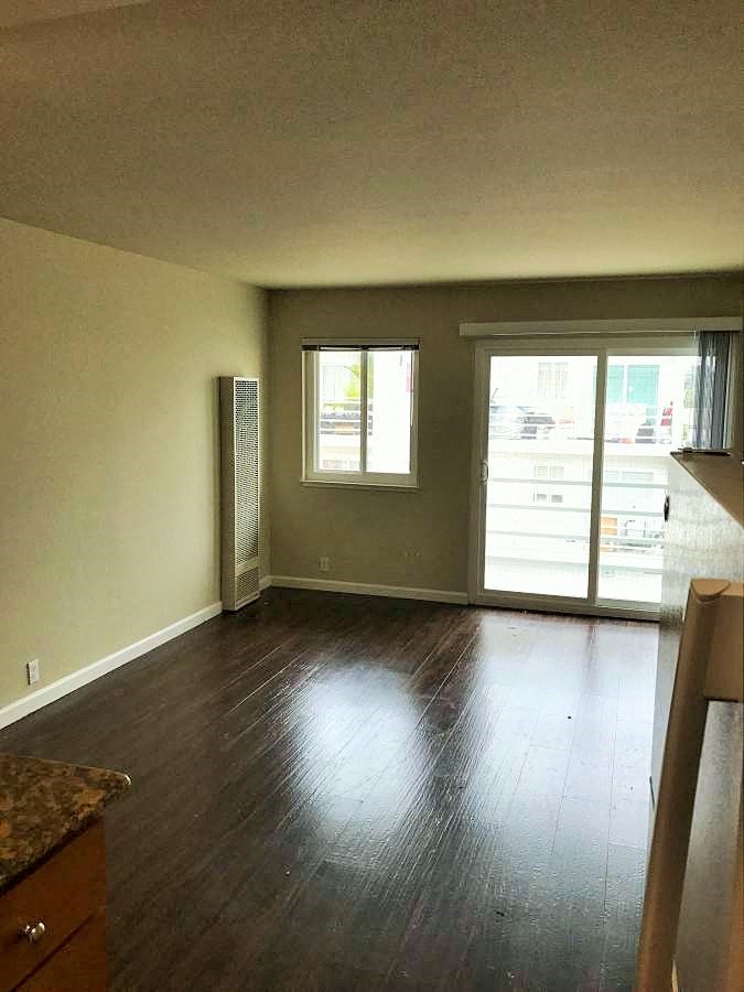 an empty living room with a hard wood floor