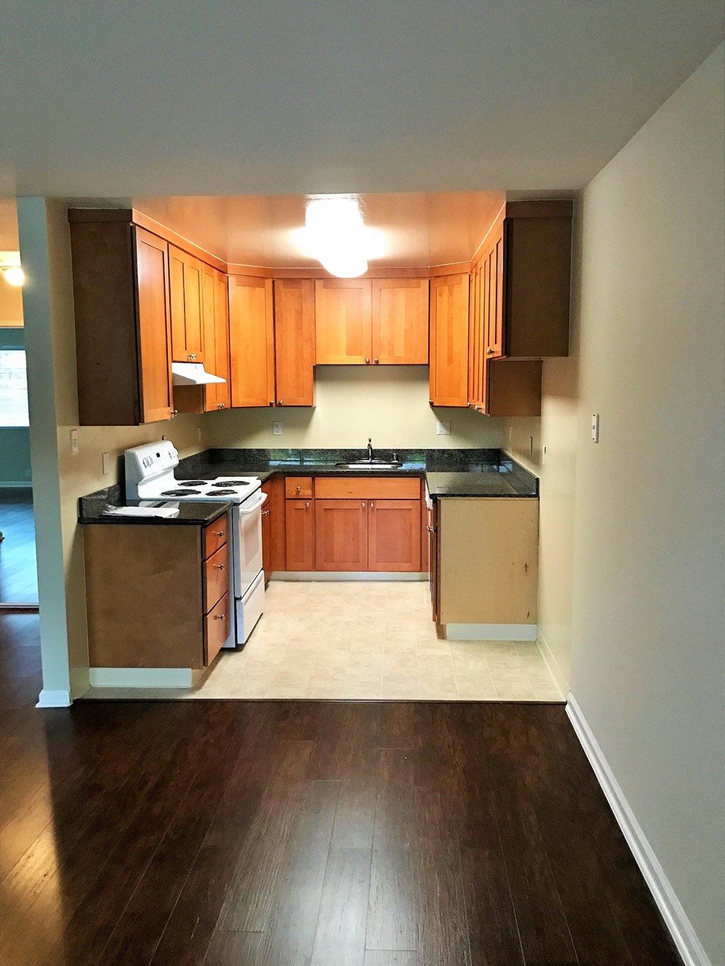 an empty kitchen with wood flooring and wooden cabinets