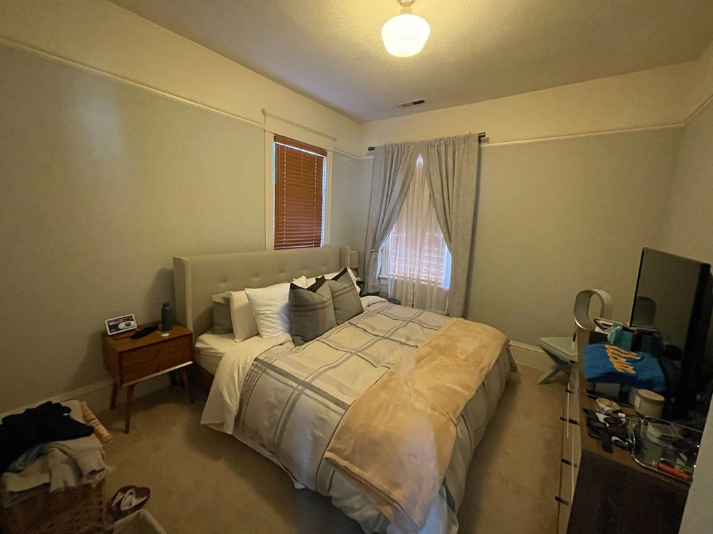 a small bedroom with a bed and a window