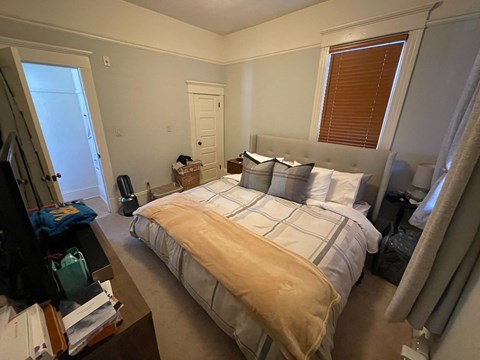 a bedroom with a bed and a dresser and a window