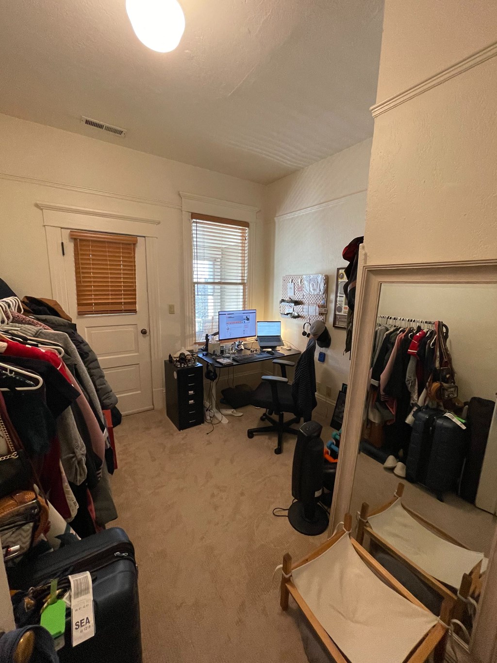 a bedroom with a closet and a desk with a computer