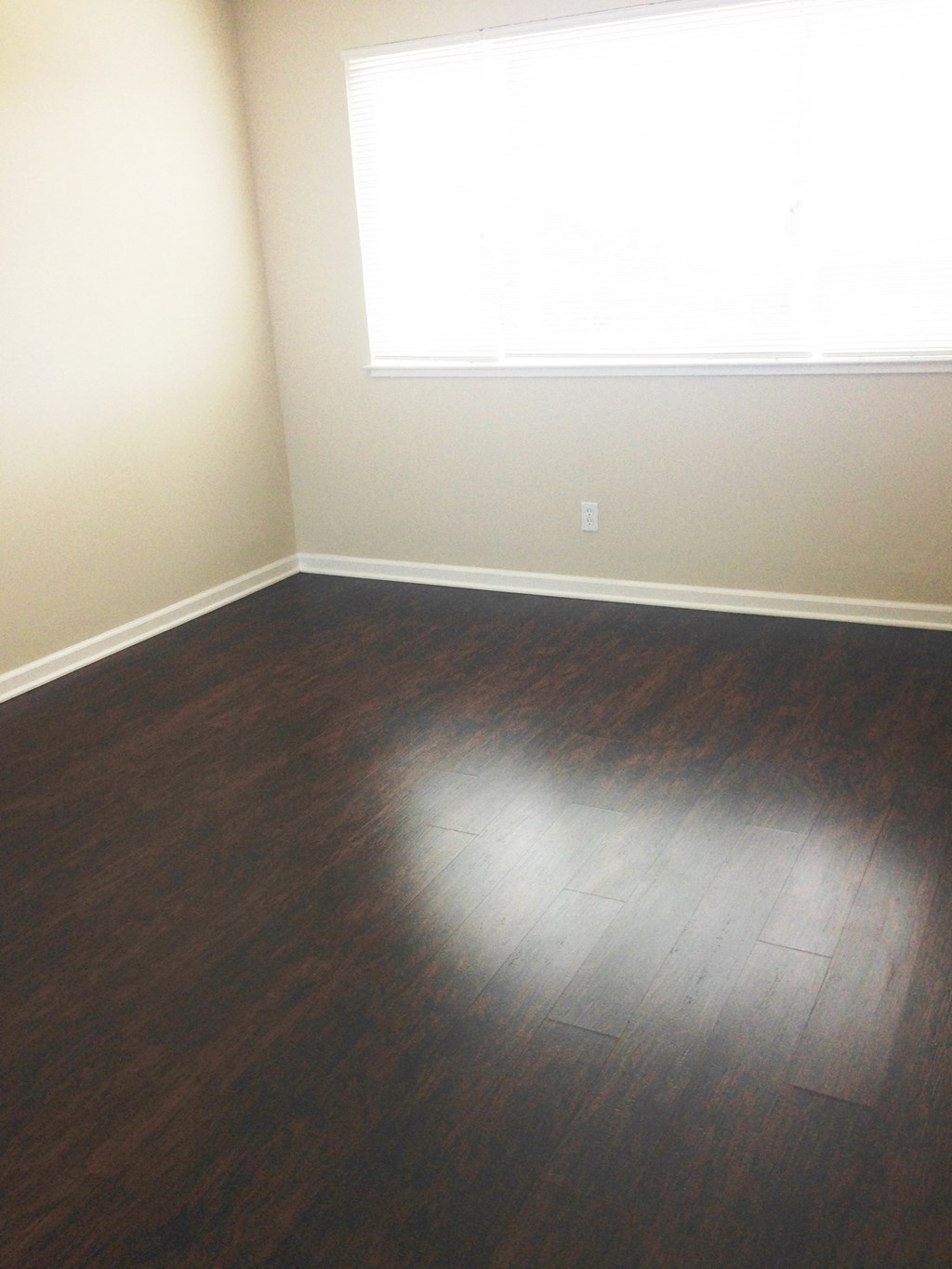 an empty room with wooden floors and a window