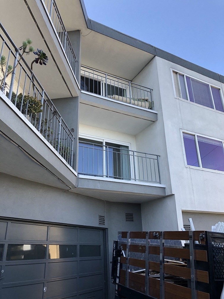 an apartment building with balconies and a garage