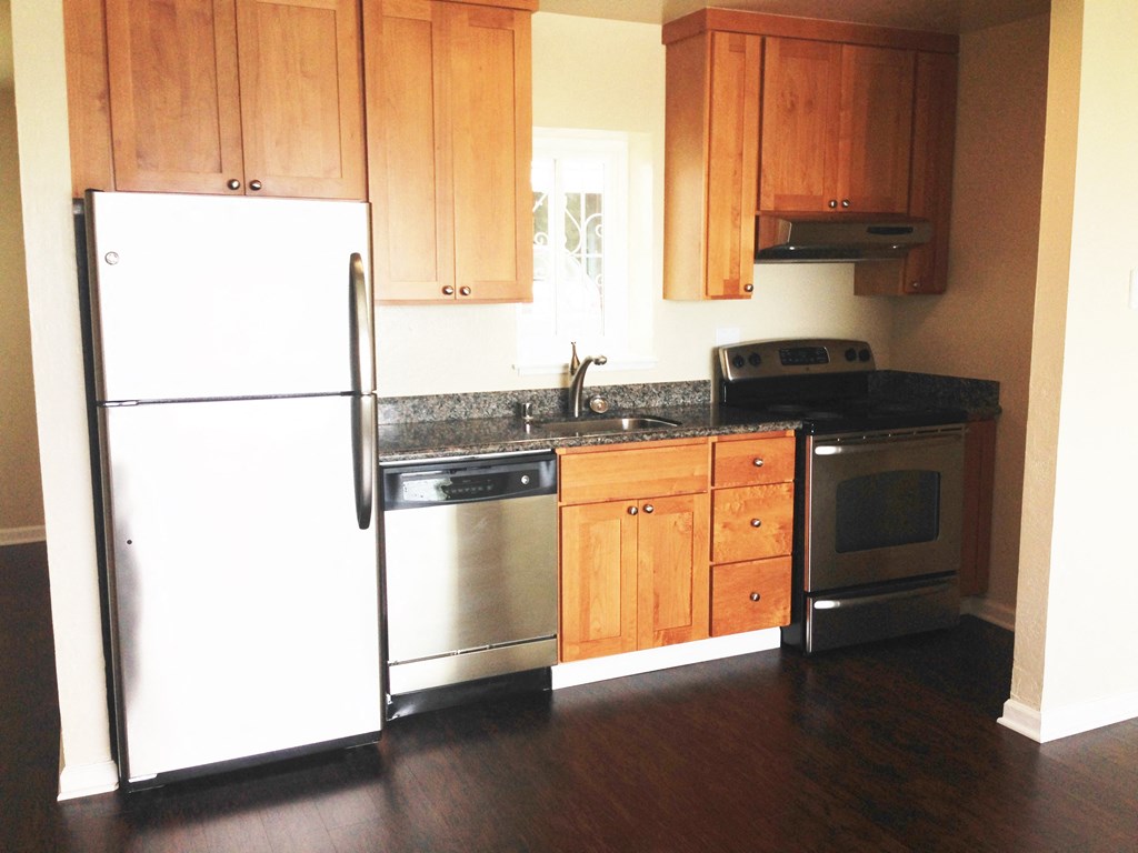 a kitchen with a white refrigerator and stove and wooden cabinets