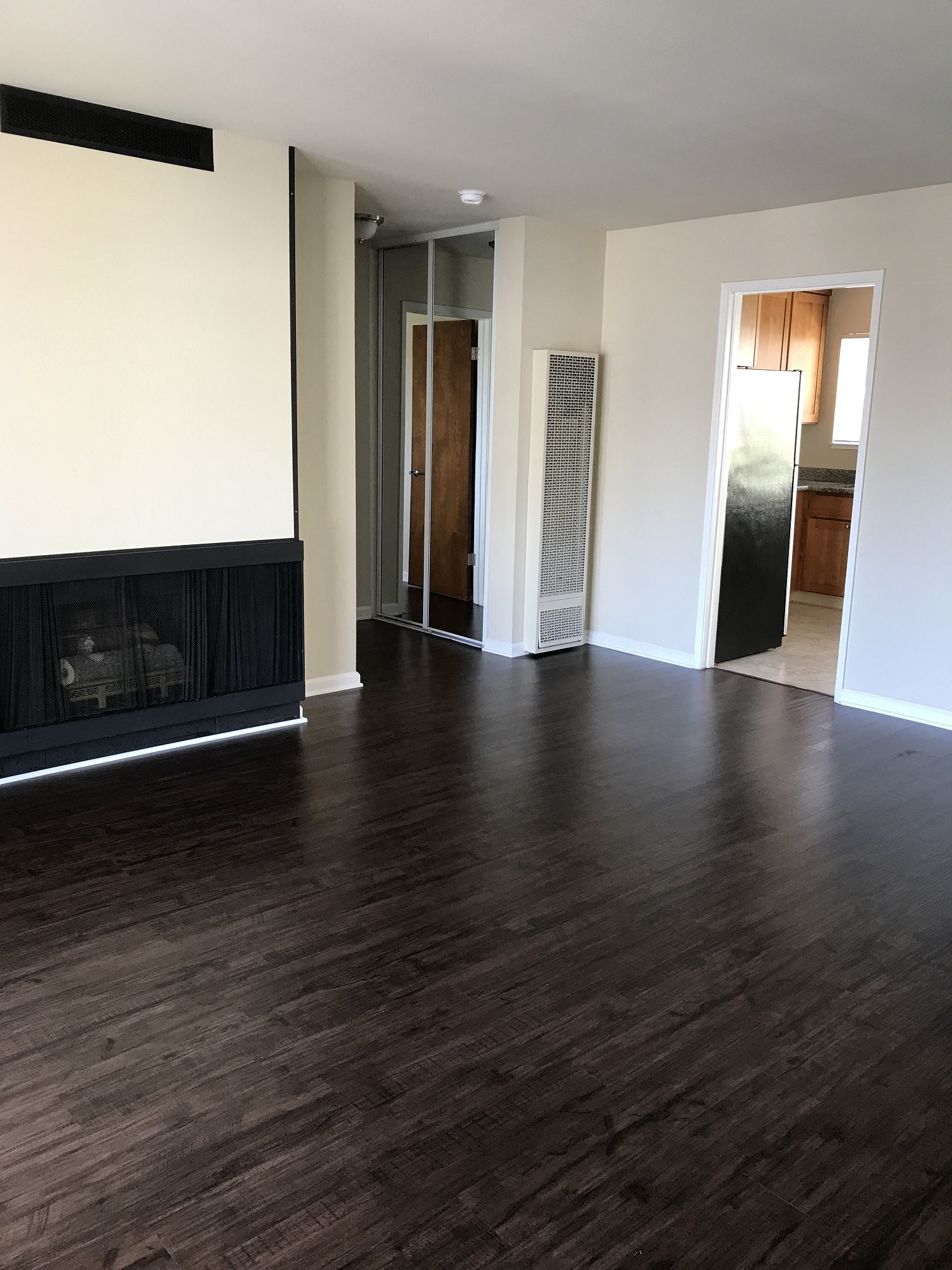 an empty living room with wood flooring and a fireplace