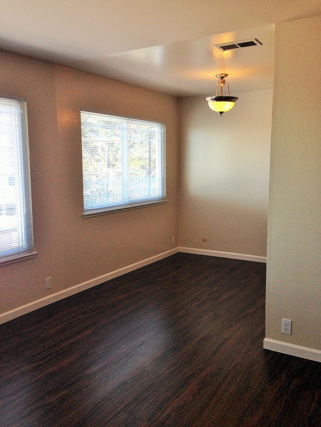 an empty room with wood floors and a window