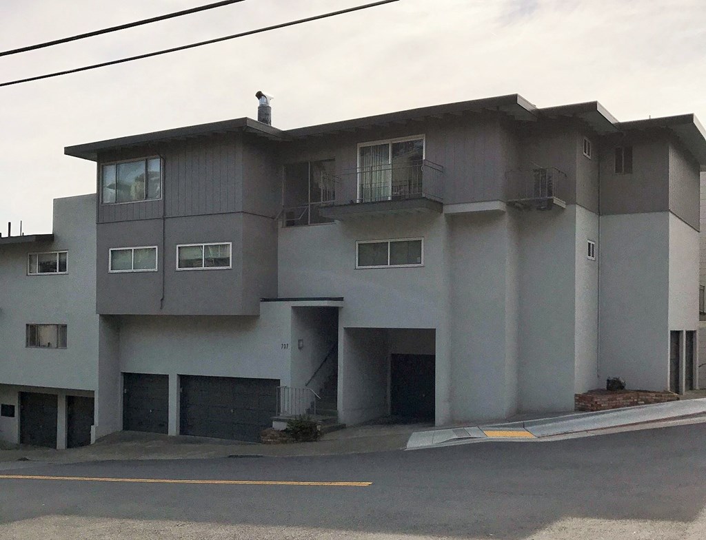 a white apartment building with a street in front of it