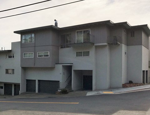 a white apartment building with a street in front of it