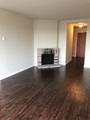 a living room with a fireplace and a wooden floor