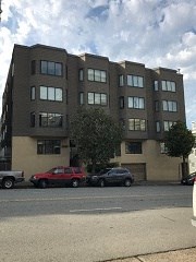 a building on a street with cars parked in front of it