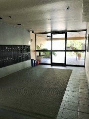 an empty hallway in a building with glass doors