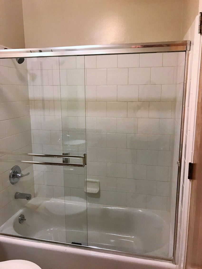 a white bathroom with a shower and a tub