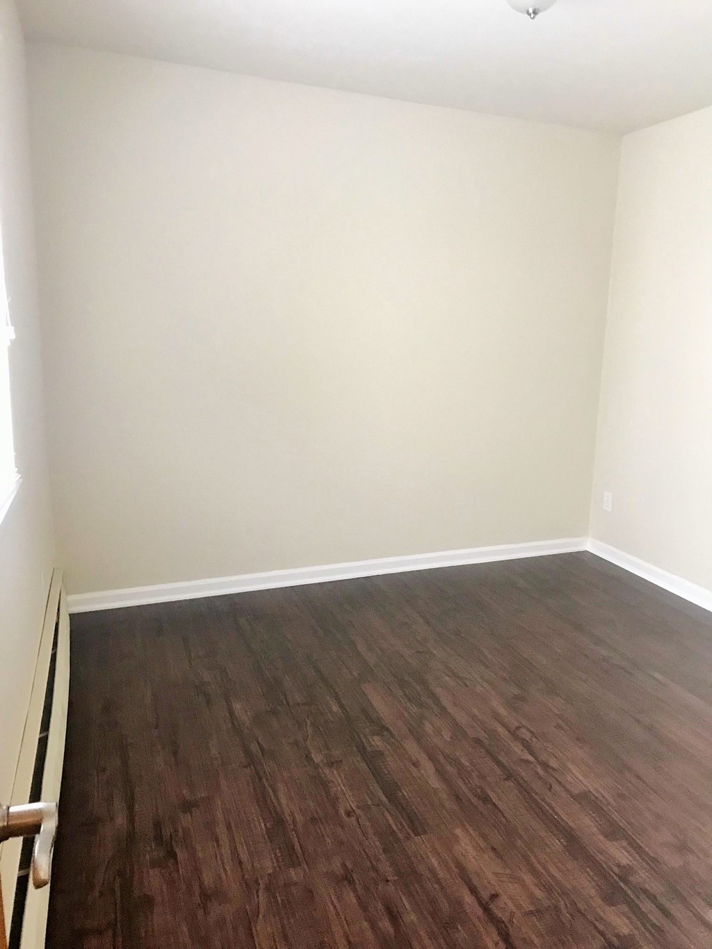 an empty room with wooden floors and white walls