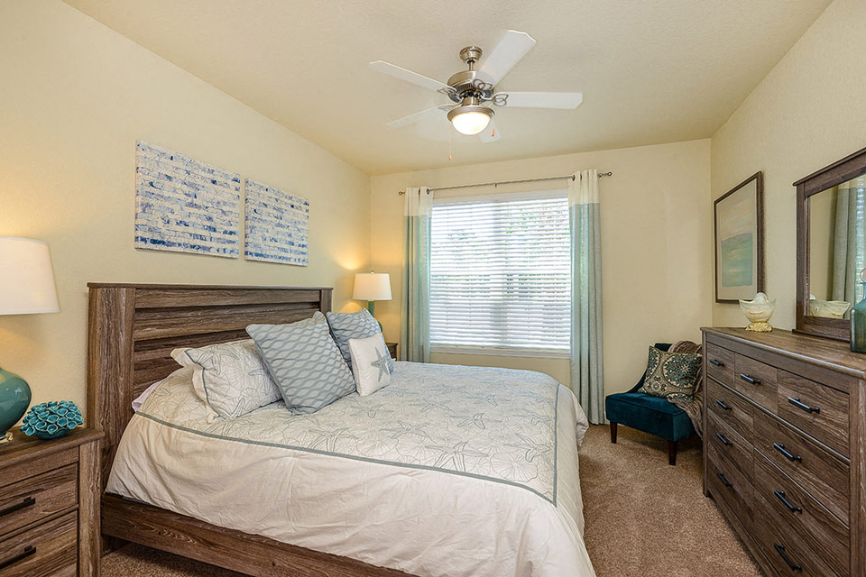 a bedroom with a bed and a ceiling fan