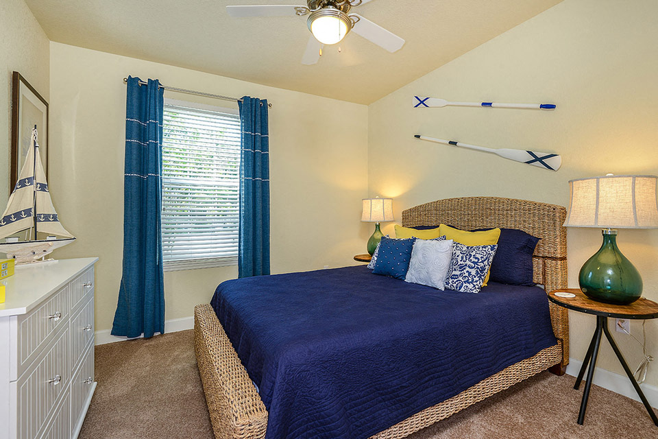 a bedroom with a bed and a ceiling fan