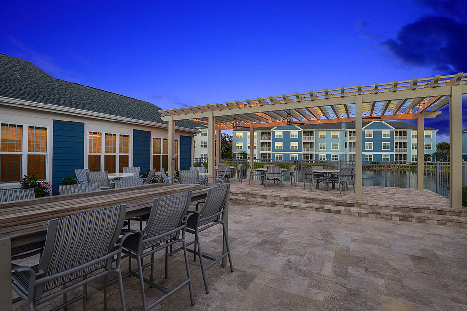 a patio with tables and chairs and a pergola