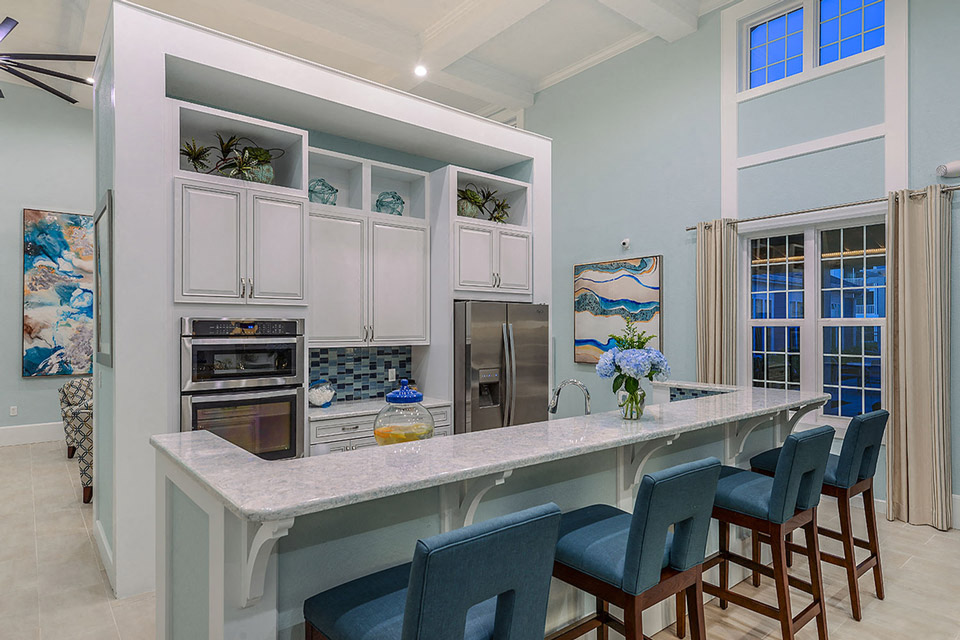 a kitchen with a large counter with blue chairs