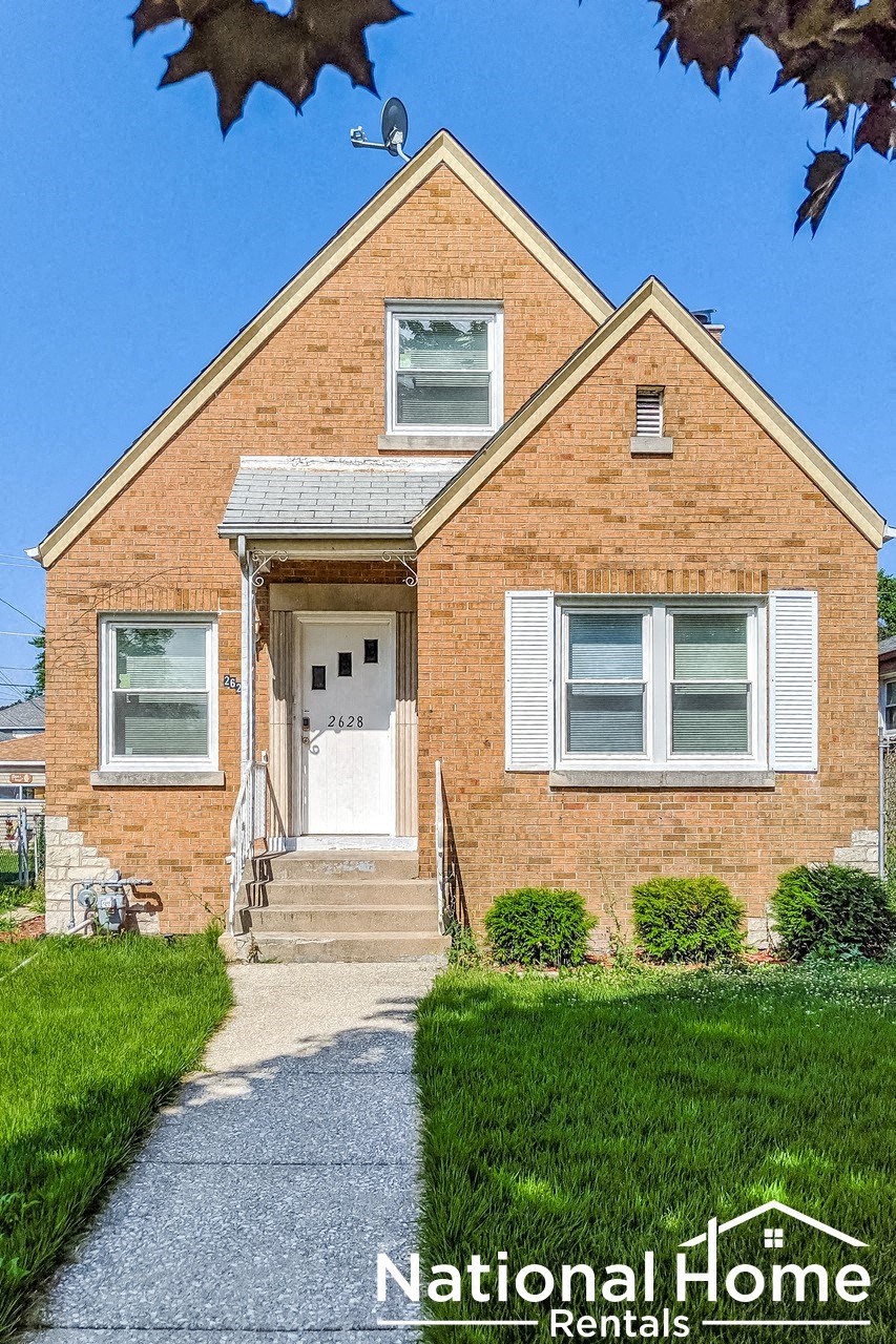 A National Home Rentals sign is displayed in front of a brick house.