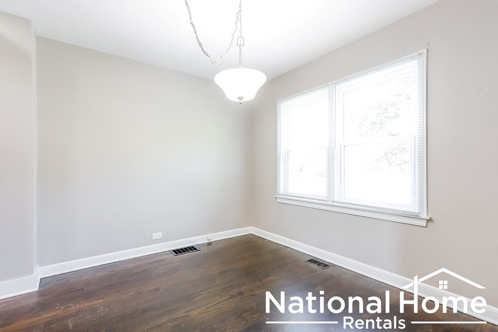 A room with a window and a light fixture from National Home Rentals.