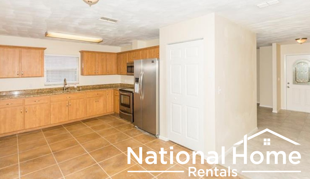 a large kitchen with wooden cabinets and a stainless steel refrigerator